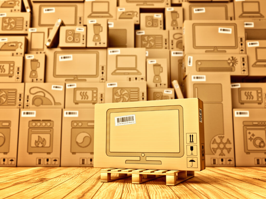 Box with a tv icon on the background of a cardboard boxes with household appliances and electronics in the warehouse